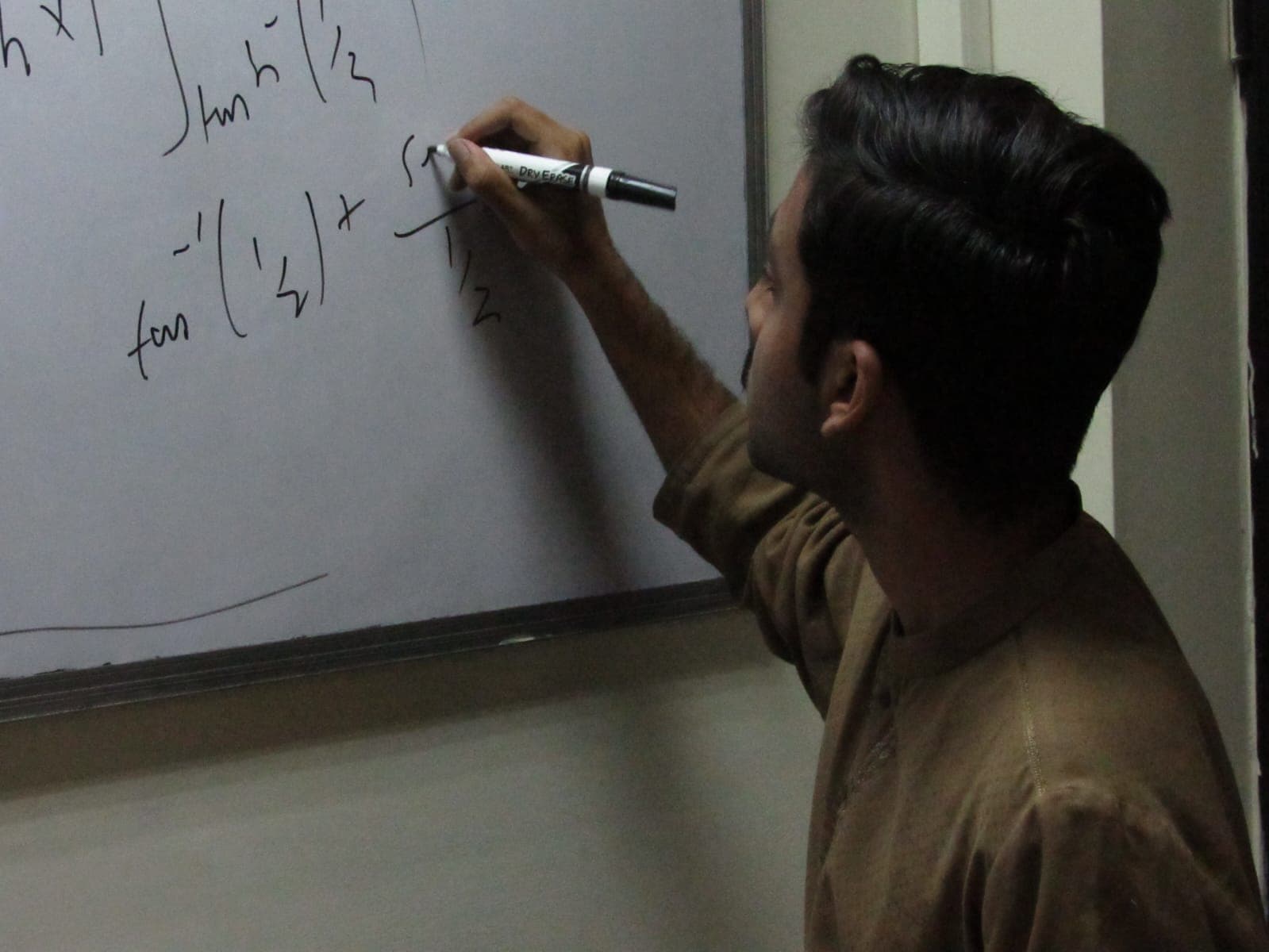 A student works through an integral on a whiteboard.